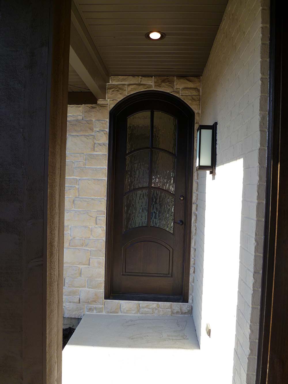 <p>Arch topped wood side door from porch</p>