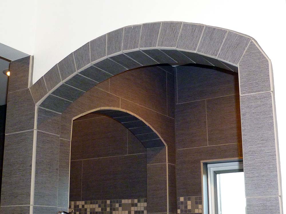 <p>Arched entry to shower with a row of tile</p>