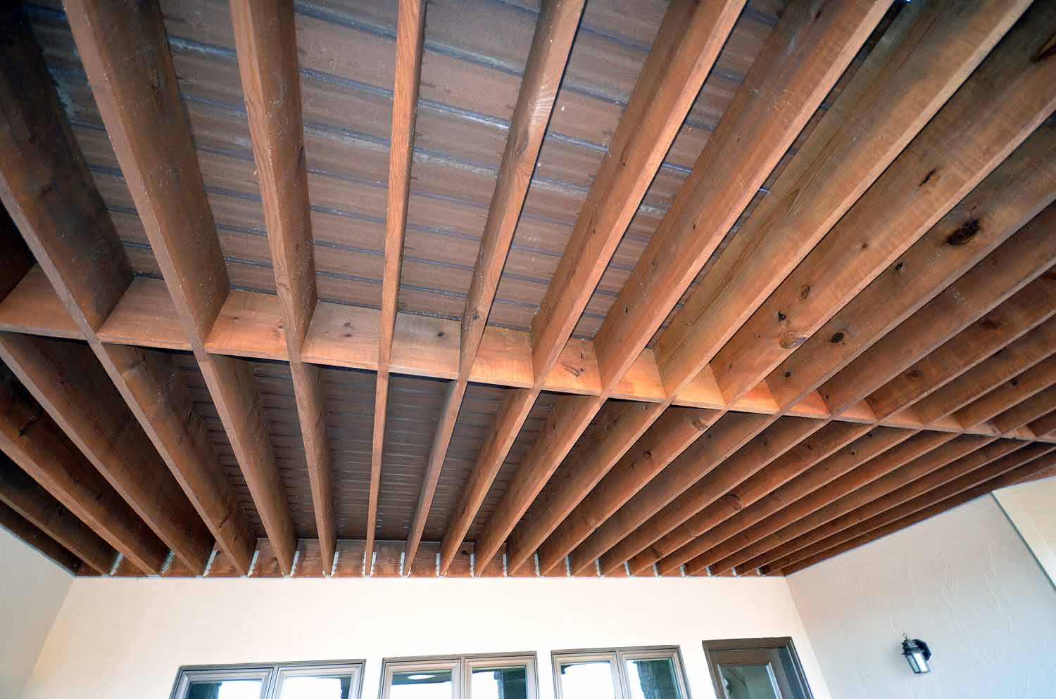 <p>Underside of wood deck that has been stained as patio ceiling below</p>