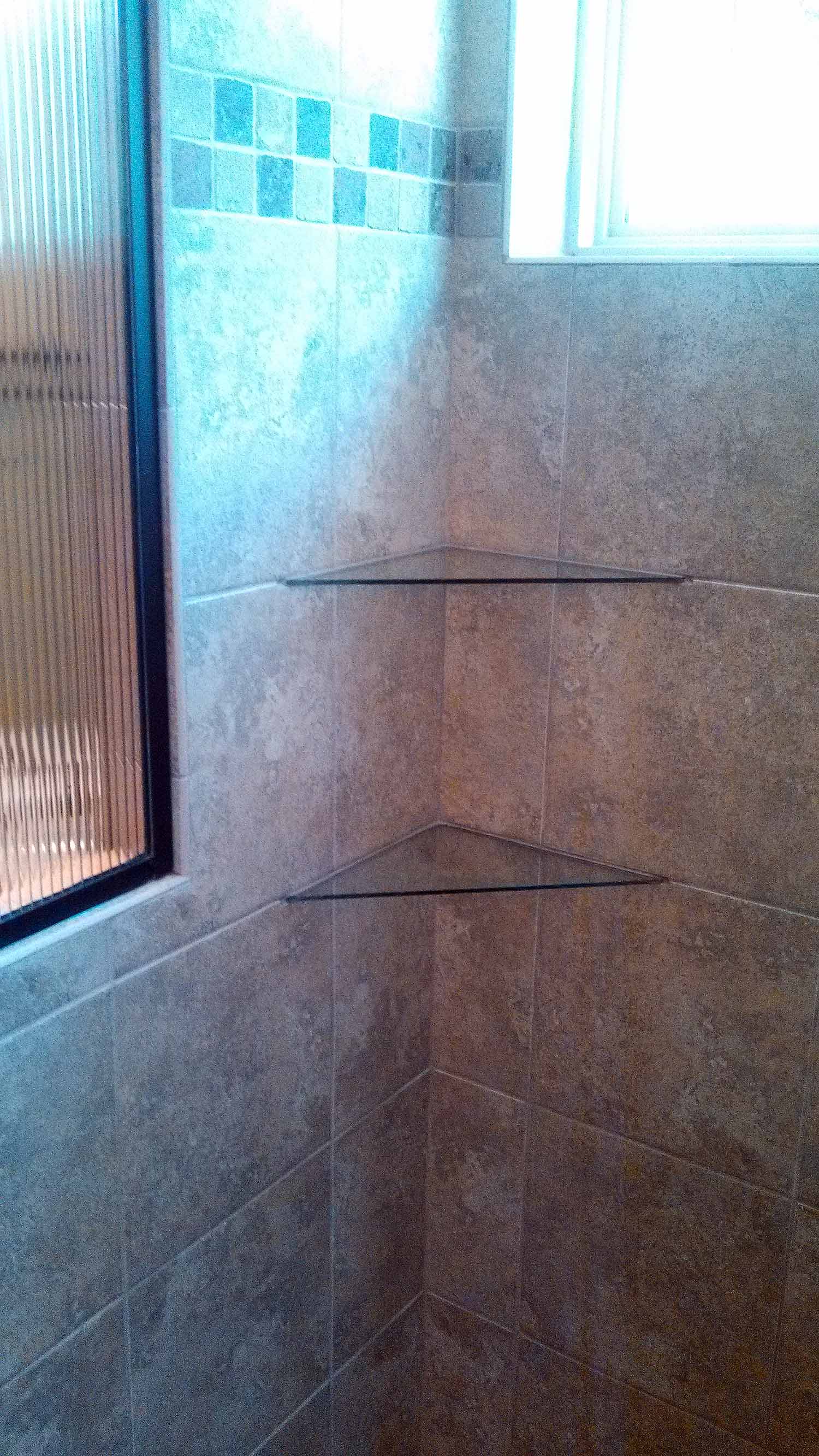 <p>Glass corner shelves in tile shower</p>