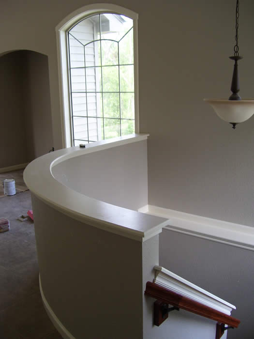 curved half wall overlooking staircase.